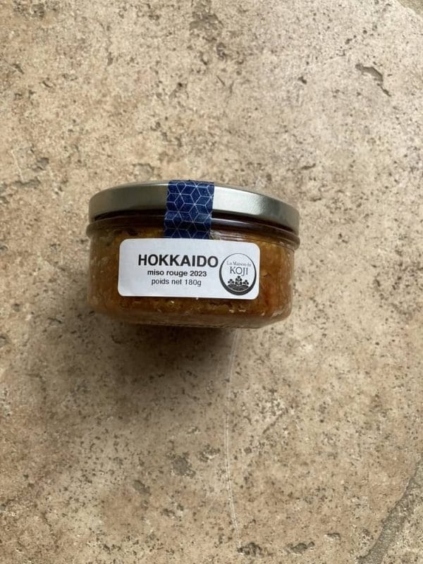 A jar of Miso rouge Hokkaido on a stone floor.
