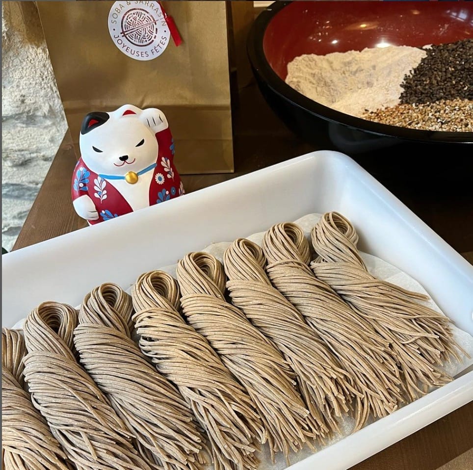 A tray of noodles with a teddy bear on it.